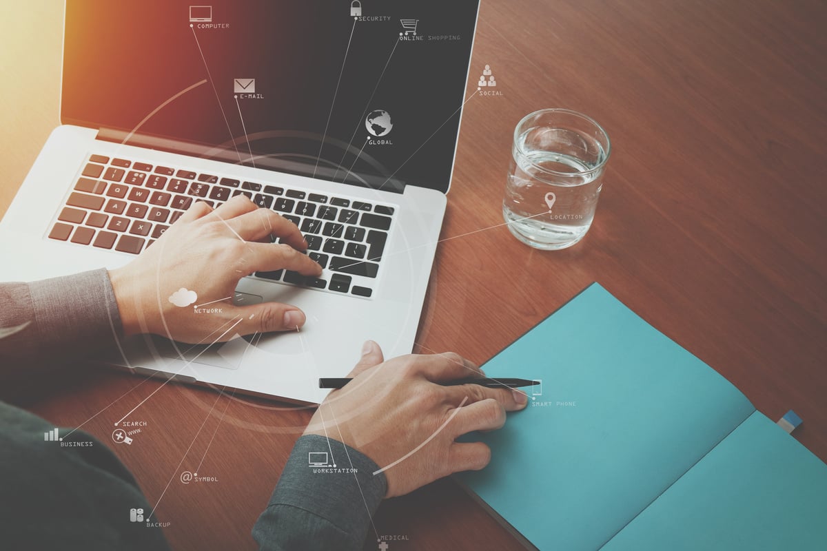 top view of  businessman hand working with laptop computer and book with VR business strategy concept on wooden desk